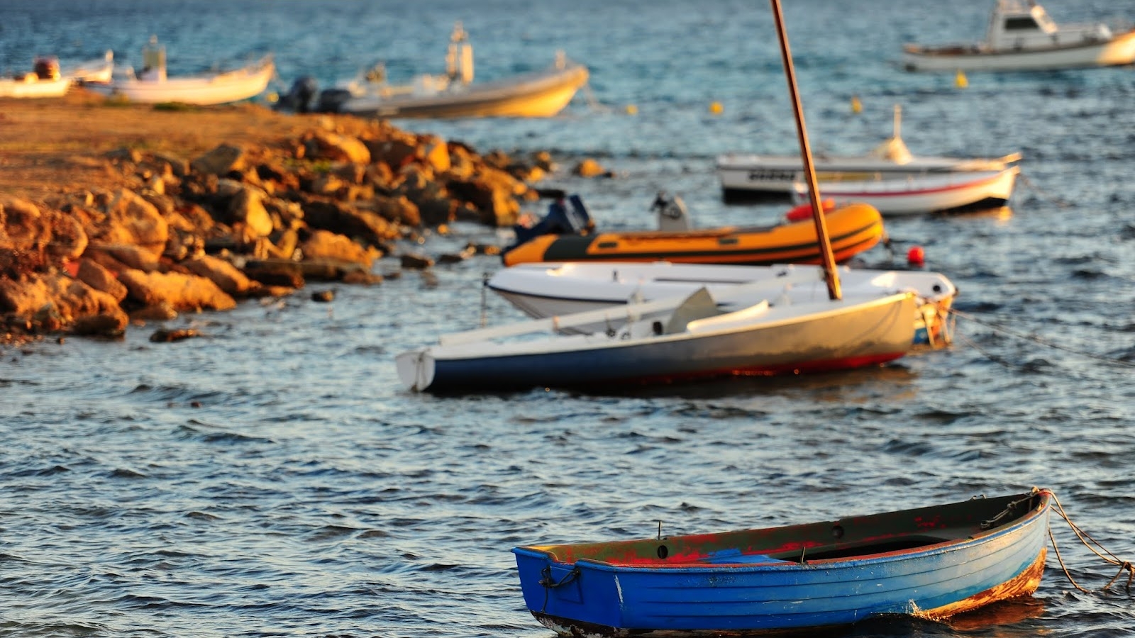Delle barche sulla riva di una costa in Sardegna al tramonto