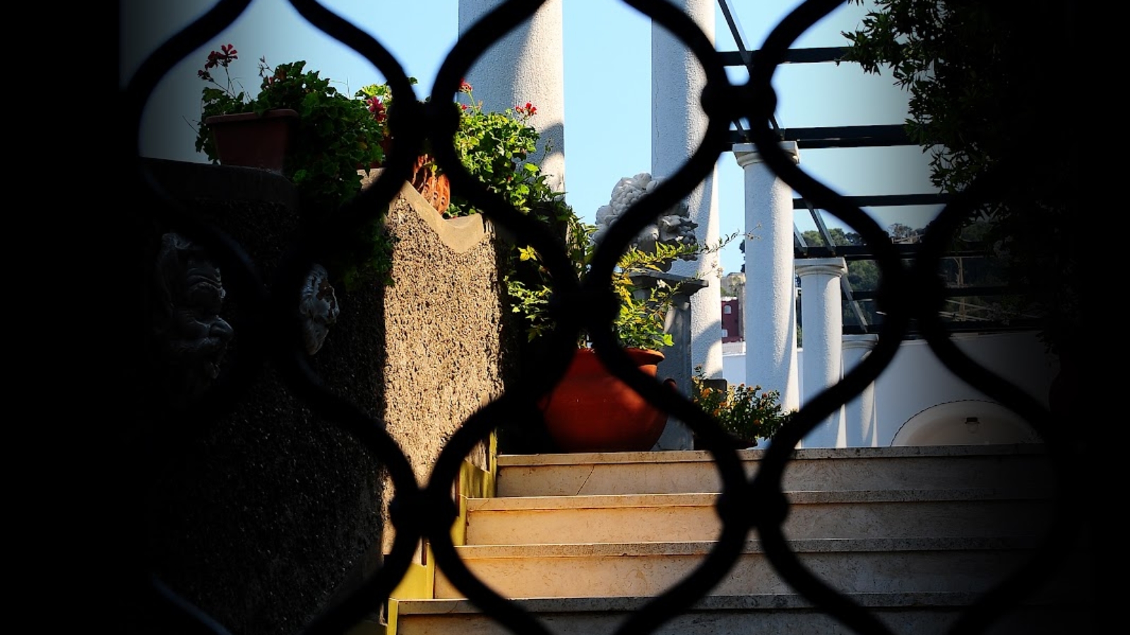 Delle colonne su una scala viste attraverso una grata a Capri